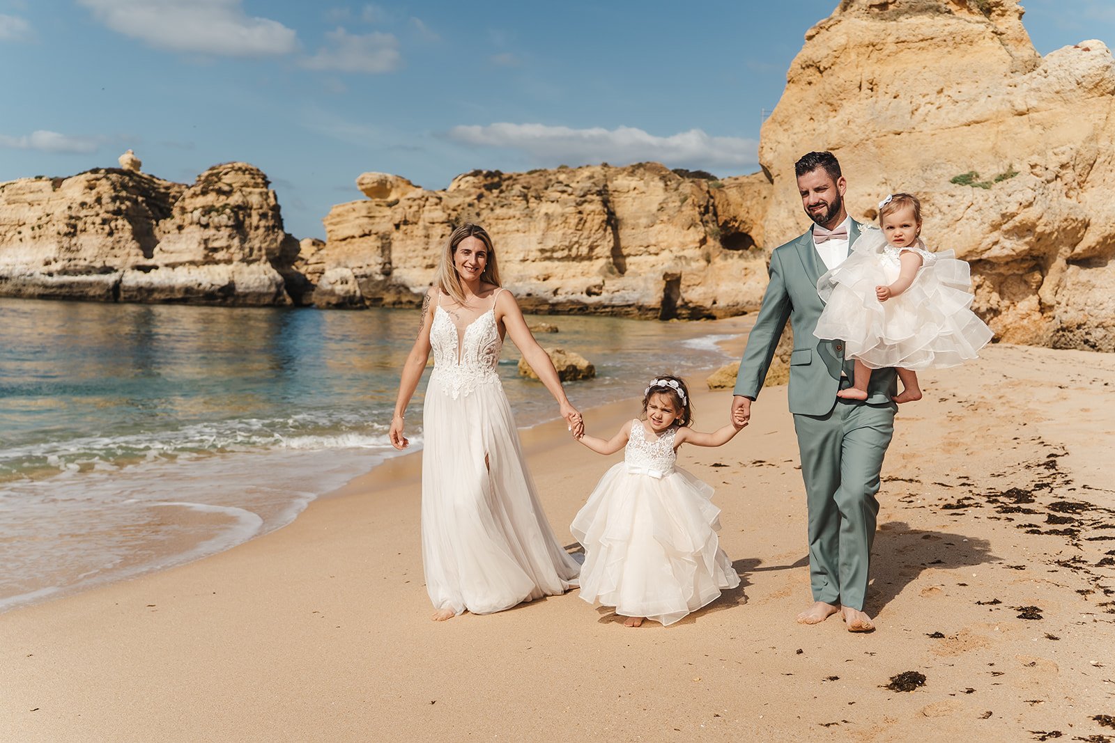 Family walking along honeycomb cliffs at Praia da Marinha, Lagoa