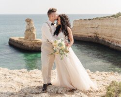 Luxury wedding photography in Algarve & Europe. Elegant, emotional storytelling by Olga & Igor Rosi. Full-day, elopement & destination packages available. Luxury wedding photography and videography in Algarve & Europe. Algarve clifftop wedding venue. Elegant, emotional storytelling by Olga & Igor Rosi, Algarve Pictures. Full-day, elopement & destination packages available. Bride and groom portrait at sunset with dramatic cliffs and ocean in Carvoeiro.